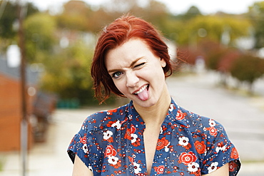 Young woman with red hair, sticking her tongue out