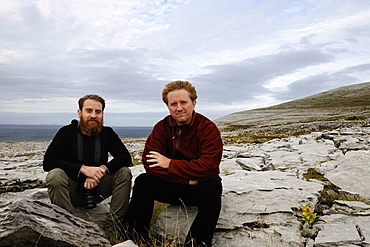 Two men sitting on rocks, The Burren, County Clare, Ireland