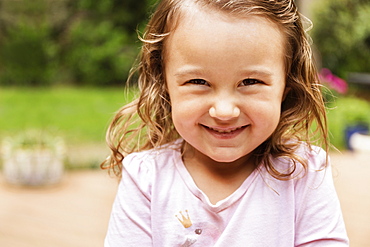 Close up portrait of smiling female toddler in garden