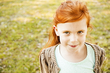 Portrait of red haired girl in park