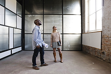 Young business partners looking at new office space