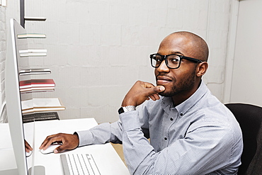 Portrait of young man using computer in design office