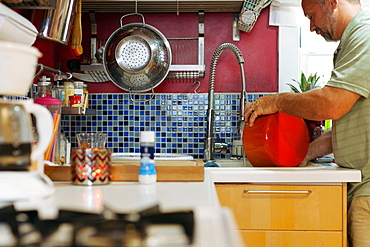 Man washing red pot