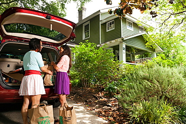 Mother and daughter unloading shopping bags