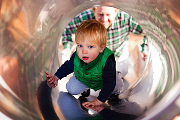 Boy climbing up slide in playground