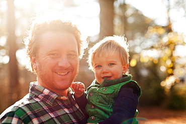 Father holding son in park