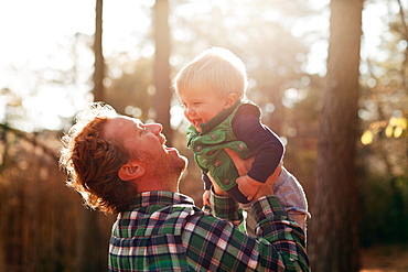 Father carrying son in park