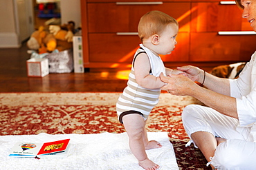 Mother and baby son playing on carpet