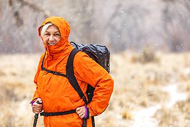 USA, Utah, Escalante, Woman hiking during snow flurry in Grand Staircase-Escalante National Monument