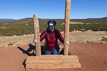 USA, New Mexico, Pecos, Woman in face mask climbing out of storage shelter at Pecos National Historical Park