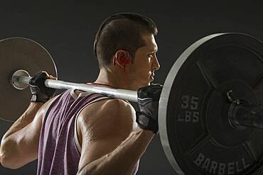 Muscular man training with barbell