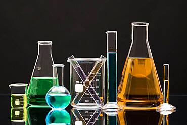 Laboratory glassware with liquids against black background