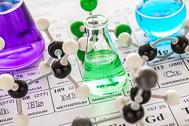 Molecular models and laboratory glassware with liquids on periodic table