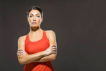 Studio portrait of athletic woman in red sleeveless top