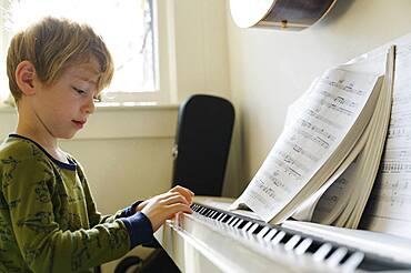 Boy (6-7) playing piano