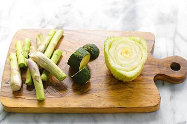 Vegetable scraps ready for compost on wooden cutting board