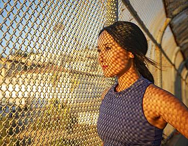 Athlete woman resting at fence