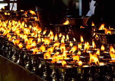 China, Tibet, Lhasa, Burning candles in Tibetan Buddhist temple