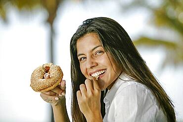 Portrait of smiling woman eating donut