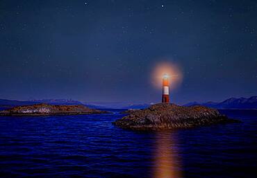 Argentina, Patagonia, Ushuaia, Beagle Channel, Illuminated lighthouse on rocky islet at night