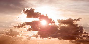 Sun peeking through dark cloud