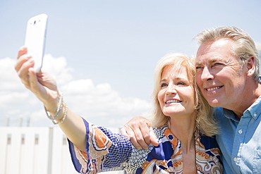 Portrait of couple posing for smartphone selfie