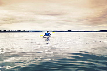 Man kayaking on lake, Olympia, Washington, USA