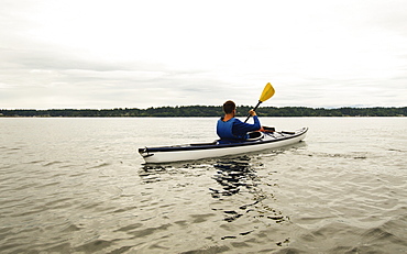 Man kayaking on lake, Olympia, Washington, USA