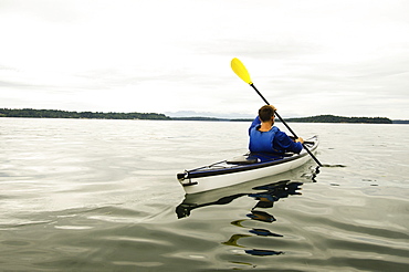 Man kayaking on lake, Olympia, Washington, USA