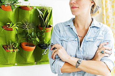 Woman standing by vertical garden