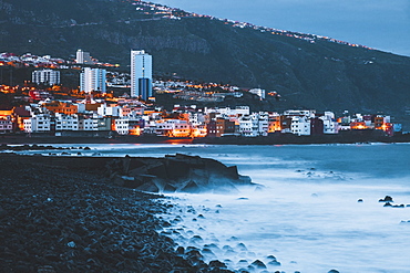 Spain, Canary Islands, Tenerife, Puerto De La Cruz, Buildings on sea coast at dusk