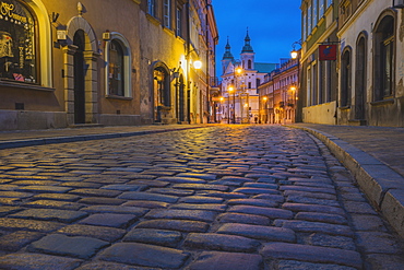 Poland, Masovia, Warsaw, Townhouses along cobblestone street in old town at night