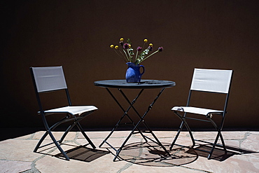 Chairs and table with bouquet on patio