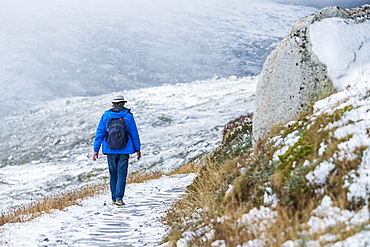 Australia, New South Wales, Woman hiking on snowy trail at Charlotte Pass in Kosciuszko National Park