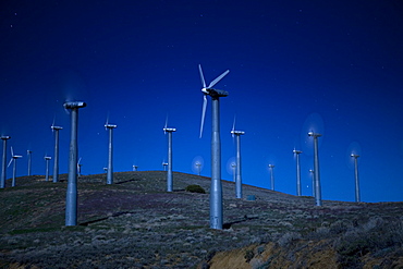 Wind turbines in landscape at night