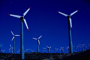Wind turbines in landscape at night