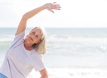 Senior woman exercising on beach