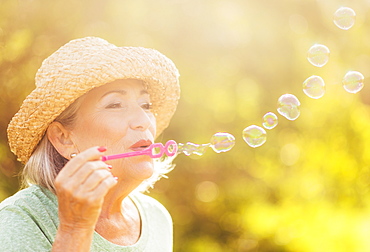 Senior woman blowing soap bubbles