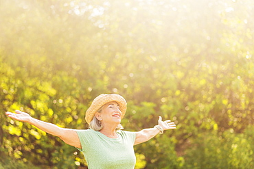 Senior woman in park with arms outstretched
