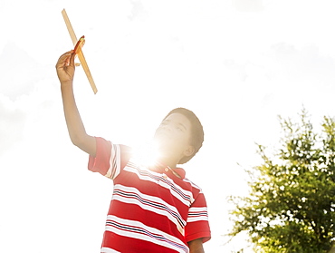 boy (6-7) playing with toy airplane