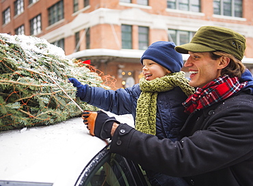 Man with kid (6-7) bonding Christmas tree, Jersey City, New Jersey, USA