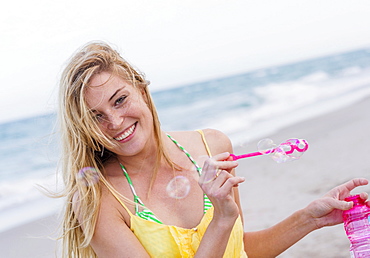 Young woman blowing bubbles, Jupiter, Florida, USA