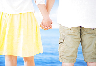 Studio Shot Mid section of couple standing and holding hands