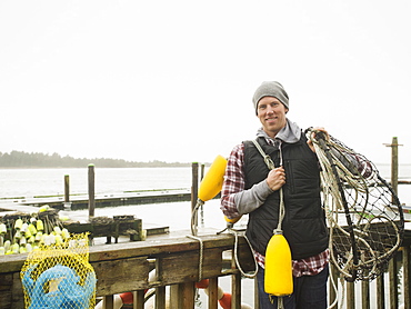 Portrait of man holding fishing equipment, Rockaway Beach, Oregon