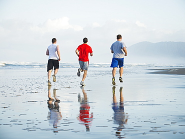 Men running on beach, Rockaway Beach, Oregon