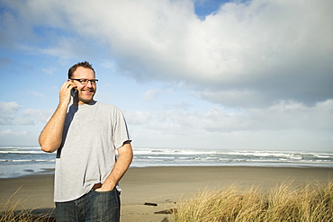 Mid adult man taking photograph, Rockaway Beach, Oregon