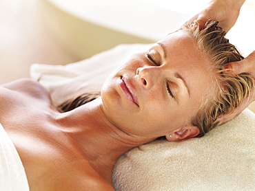 Mid adult woman receiving head massage