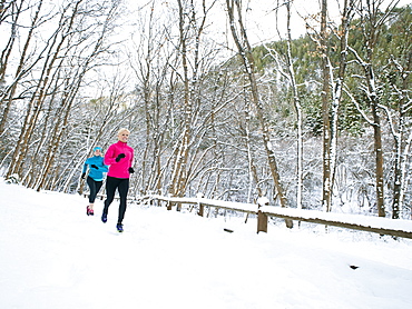 Two women jogging in winter forest, Salt Lake City, Utah USA