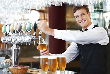 Portrait of bartender pouring beer