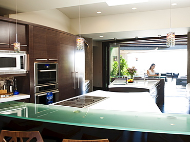 Young woman bustling around in modern domestic kitchen